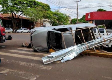 Carro carregado com calhas capota após colisão e mulher fica ferida