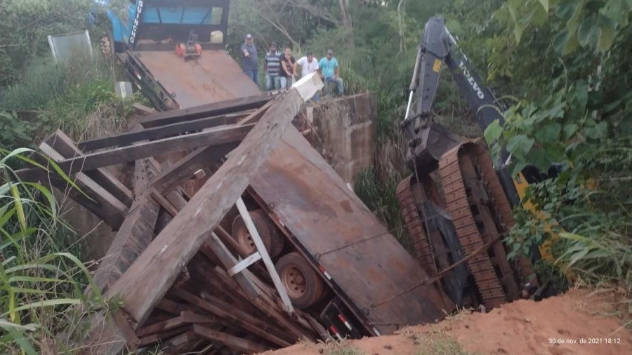 Escavadeira despenca de caminhão guincho após ponte desabar