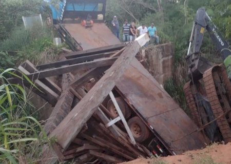 Escavadeira despenca de caminhão guincho após ponte desabar